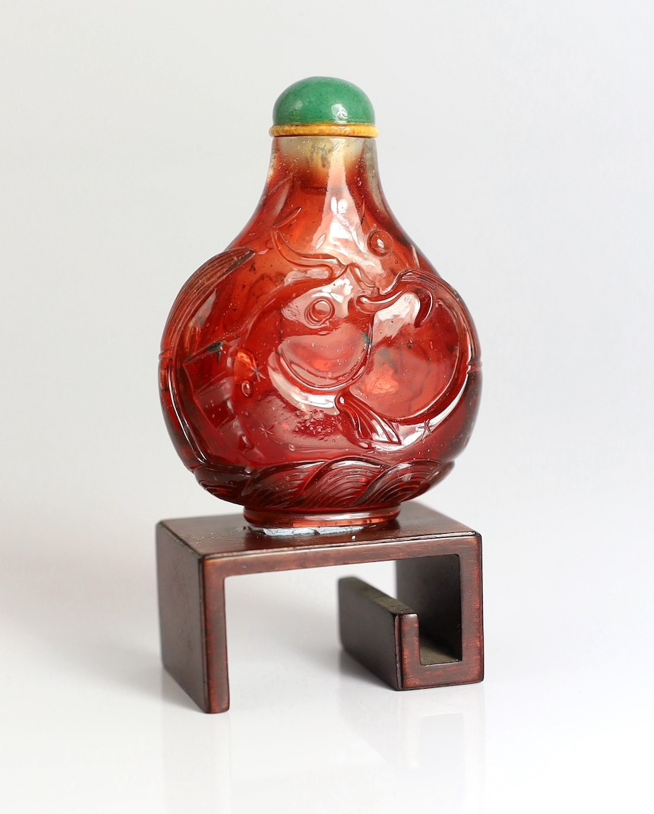 A Chinese ruby red glass ‘leaping carp’ snuff bottle, 1750-1850, 5.9cm high